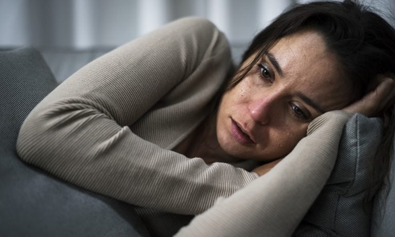 woman in emotional distress lying on side 768