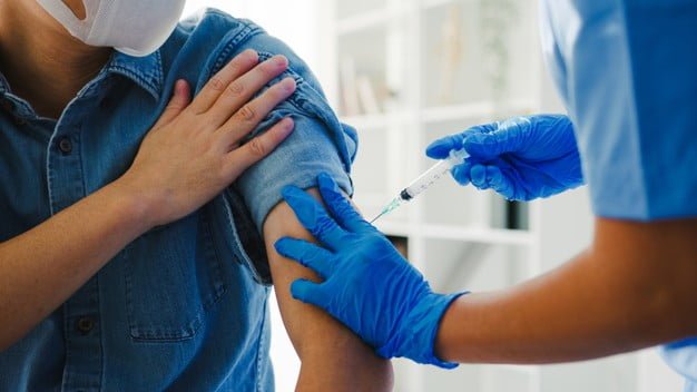 Nurse giving covid-19 flu antivirus vaccine - Photo by tirachardz