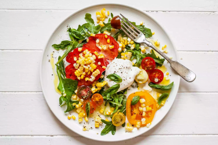 Tomato, corn, and burrata salad with arugula - Photo by Sally Vargas